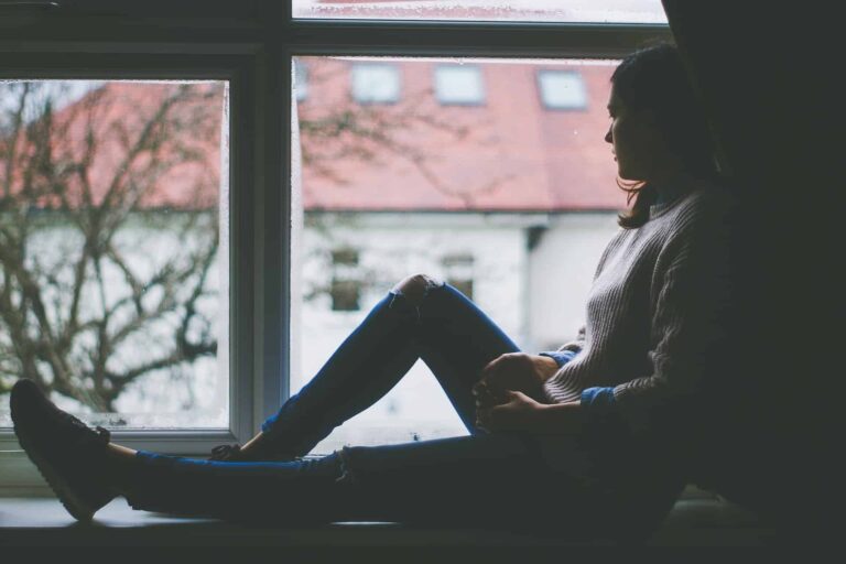An woman looking forlornly out a window
