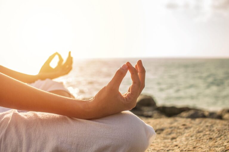 A close up of the hands of a person meditating 